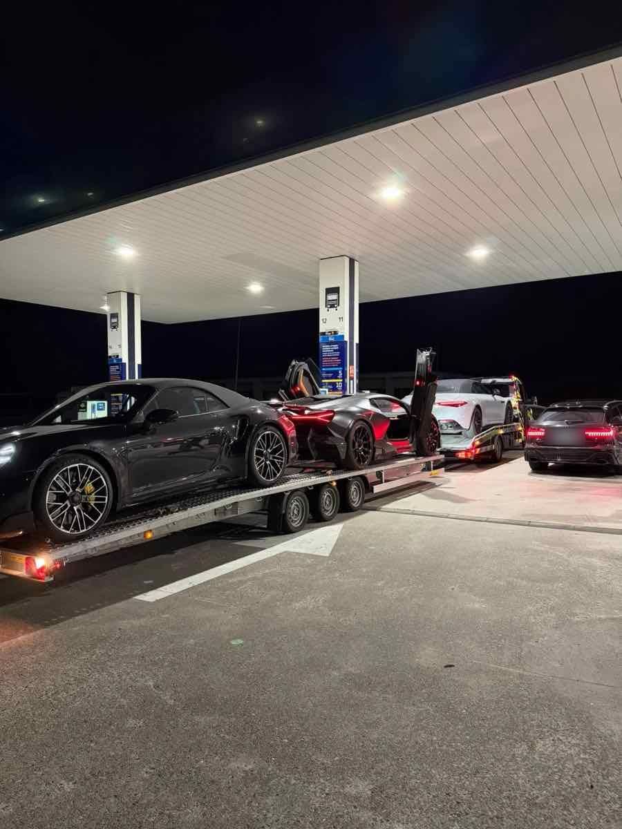 Porsche 911 Turbo S et supercar sur la remorque, de nuit en station-service