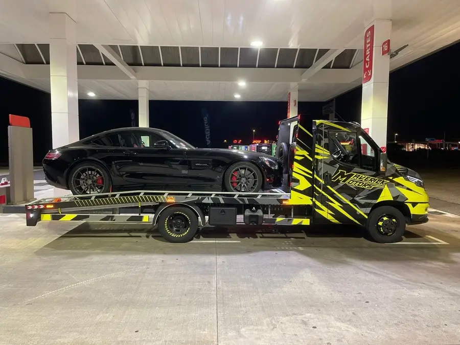Dépanneuse MAVERICK MOTORS transportant une voiture de sport de nuit
